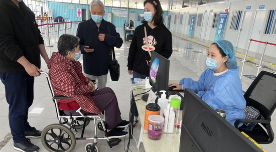 成都高新区桂溪街道交子公园接种点，医护人员正在为老年人服务。