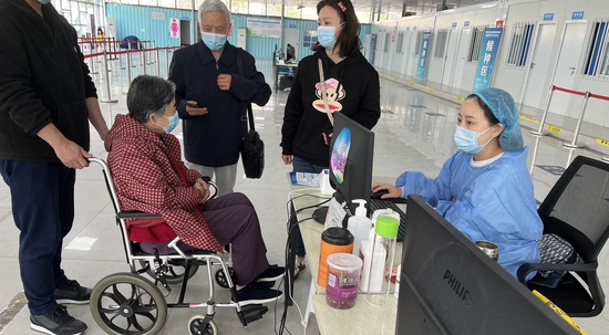 成都高新區(qū)桂溪街道交子公園接種點,醫(yī)護(hù)人員正在為老年人服務(wù)。