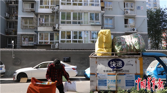 11月12日,一位快递小哥正在整理上午需要配送的快递,在他11日配送的快递中,一少半是塑料包装。中青报·中青网见习记者 赵丽梅/摄