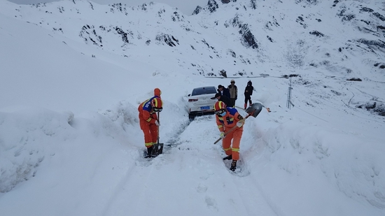 消防员帮助被困人员清理道路。