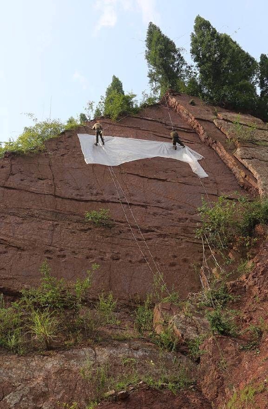 专家在古蔺县的悬崖上采集恐龙足迹数据。