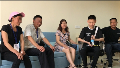 小新(右二)与亲生父母、养父母坐在一起