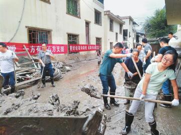 “8·20”强降雨特大山洪泥石流灾害发生后,汶川县财政局干部职工带头为当地群众清淤。