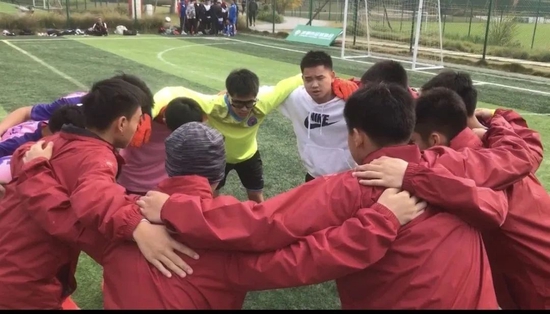校足球队员与教练员共同加油打气