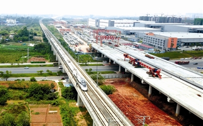 建设中的天府机场高速公路（天府新区新兴工业园附近），旁边为从成都开往重庆方向的动车。 　　成都商报-红星新闻记者 王红强 摄影