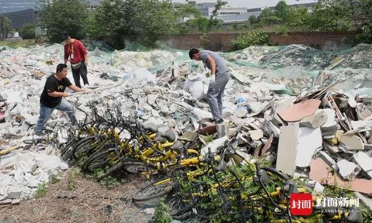 工作人员挖出上百辆被“活理”的共享单车。