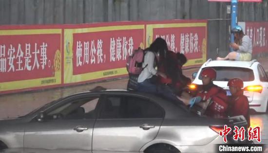 圖為民眾被積水圍困,消防人員出警救助。 何洲 攝