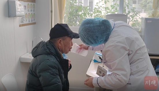 12月22日下午，张智玲正在引导73岁的刁华光接种“吸入式新冠疫苗”。周芷冰/摄