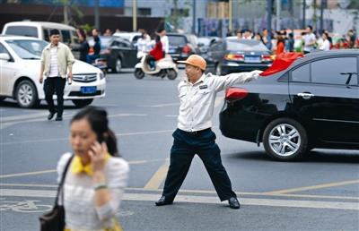 2014年5月2日,蜀都大道上,交通协管员童元成正在奋力指挥交通 成都商报记者 王效 摄
