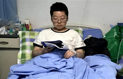 在病床上看书的刘盛 图据“掌上资阳”