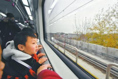 试乘的孩子们好奇地看着车窗外的风景。 本报记者 杨树 摄