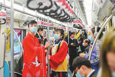 11月21日,陈随意(左)与“同袍”身着汉服,在成都搭乘地铁出行。