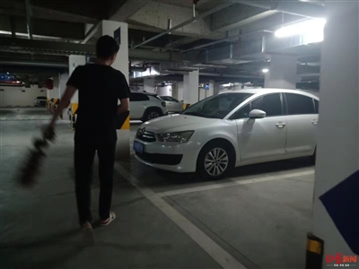 当事人朋友拿着鸡毛掸子清理被弄脏的车