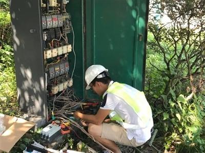 工作人员正在对南湖片区的配电柜进行检查