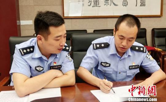 郑俊良(右)绘图讲述救人经过。 钟超 摄
