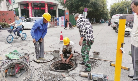 工人正对燕山街一处问题井盖进行修复。