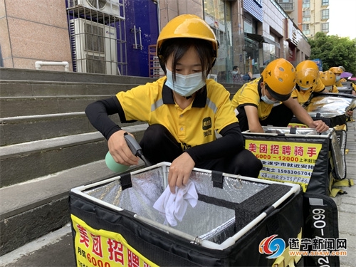 外卖配送员正在对餐箱进行消毒擦拭