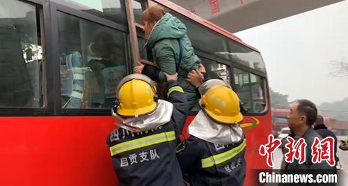 　消防员协助乘客从受损客车窗户转移。　谢洪磊　摄
