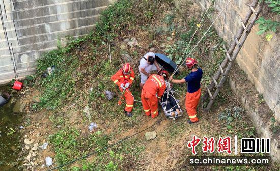 参与救援的村民（白衣者）为伤者撑起伞避雨。毛成烨摄