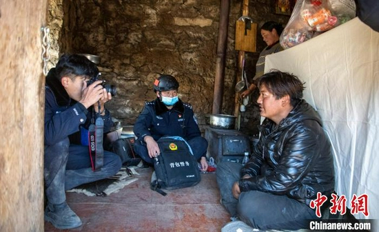 民警给农牧民甲拉拍摄身份证照片。 刘忠俊 摄