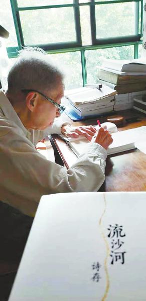 流沙河在自己的新书上签名。吴献 摄