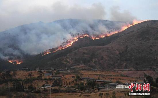资料图：4月1日，四川西昌响水沟森林大火逼近一村庄。中新社记者 刘忠俊 摄  