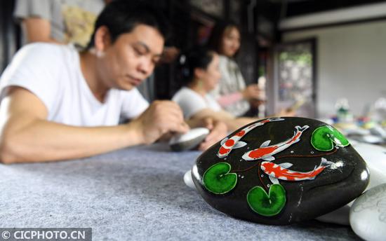 2020年6月12日,四川省南充市蓬安县嘉陵江石画工坊的画师在制作石画。CICPHOTO/刘永红 摄