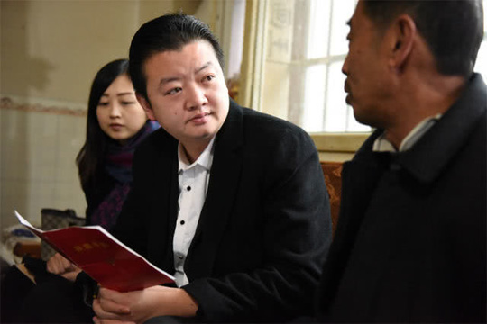 四川省叙永县后山镇三斗米村驻村第一书记胡凌鸣(中)在搬迁户陈明中(右)家了解脱贫后的情况(1月15日摄)。新华社记者 谢佼 摄