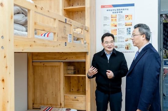 田间在新川学校创始人陈星海陪同下，参观学生宿舍