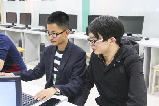 电子商务1班的周祝宇同学正与李晓峰同学交流学习