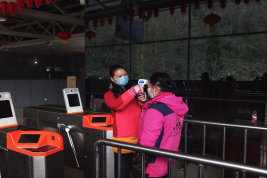 （谭敏坚守雪山一线为在岗职工测量体温）