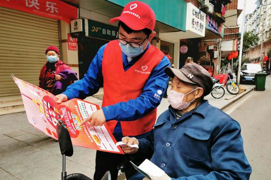 国网遂宁供电公司员工在街头向群众介绍“国网四川电力”微信公众号