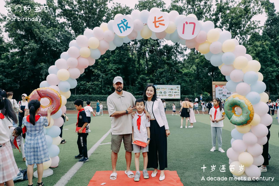 家长和孩子在成长之门下合影留念