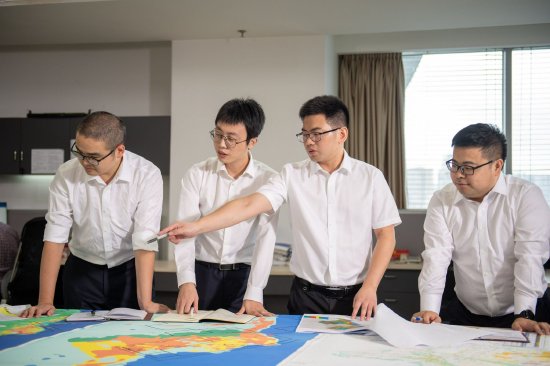陈康（图中右二）带领青年员工研讨技术难题