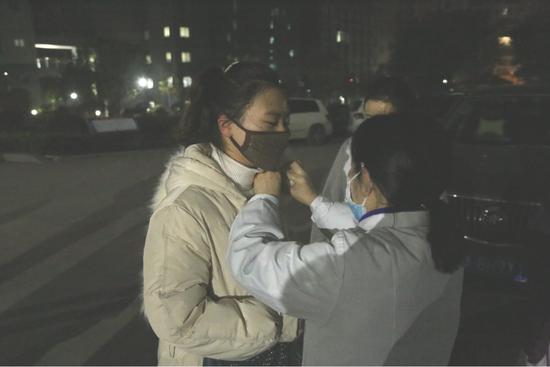 感染科护士长曹琼为她的“孩子”段炼整理衣服（左一）