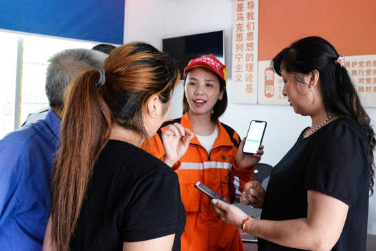 国网广安供电公司营业班工作人员正在向群众介绍传“网上国网”APP使用方法