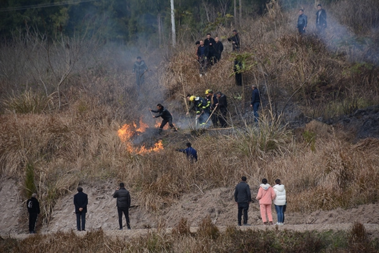 消防队员和当地村干部一起将火扑灭。