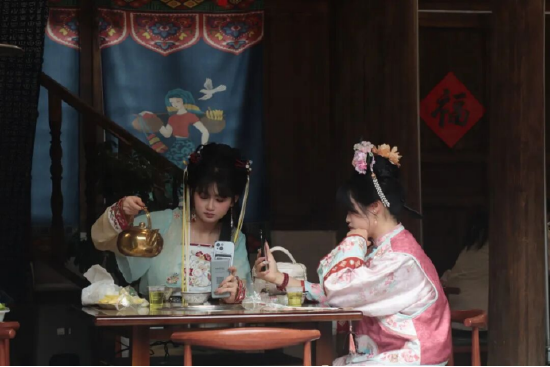 身着特色服饰的游客，在古城小吃店休憩