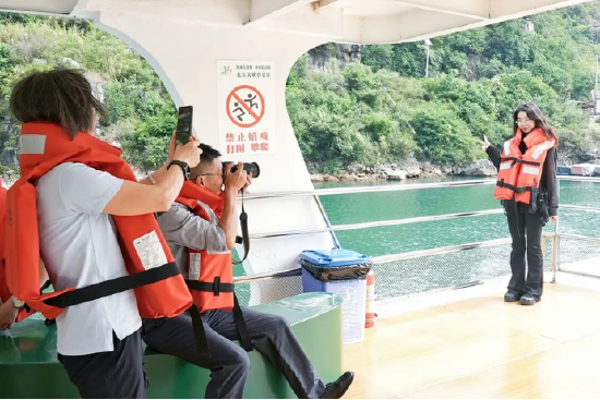 游客在渡轮上与峡谷美景拍照