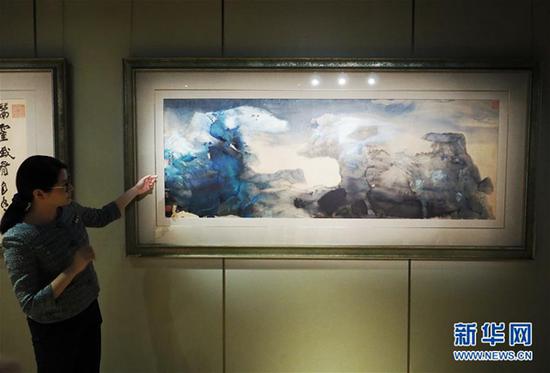 3月初,香港苏富比2018年中国书画春拍举行传媒预展。工作人员介绍张大千作品《春山瑞雪、行书七绝》。