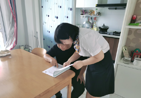 图：滁州分公司客服中心工作人员上门为老年客户讲解保险条款