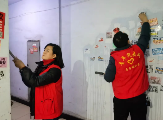 马房坝社区组织志愿服务队伍，开展小广告集中清理整治工作