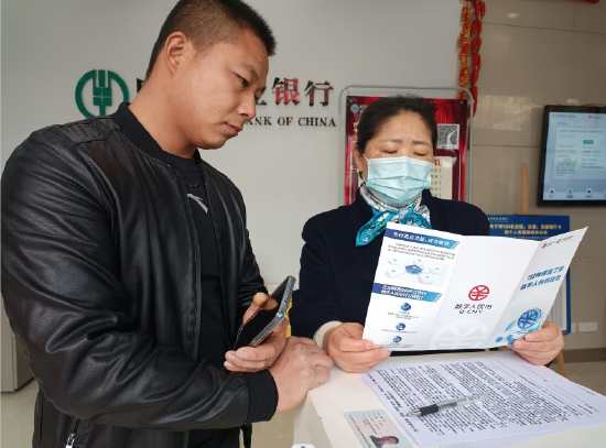 農行通川來鳳支行大堂經理正在向一名客戶講解數字人民幣知識