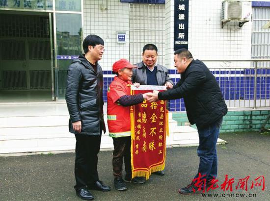 杨兵向范登星赠送锦旗,感谢她拾金不昧的行为。
