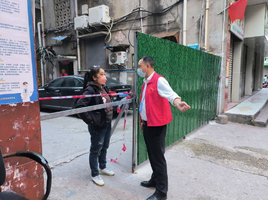 大英县司法局党组成员、副局长查小兵在育才路包保小区对居民进行疫情防控政策宣传