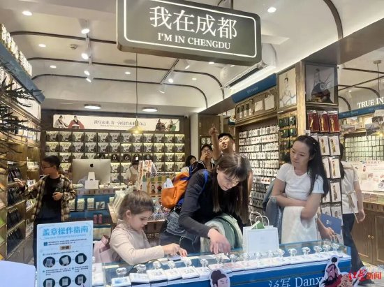 ▲朱莉亚带着孩子在刚刚购买的明信片上盖章