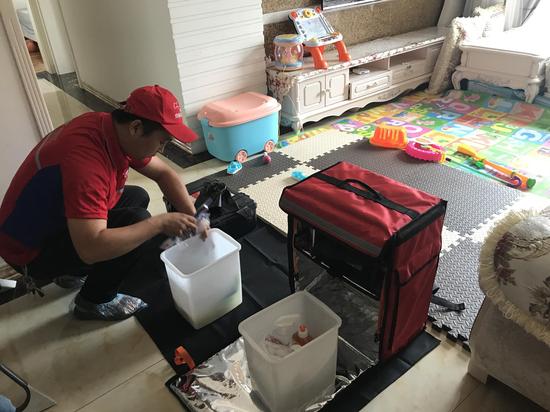 “京东帮智慧社区店”服务工人正在上门提供清洗服务