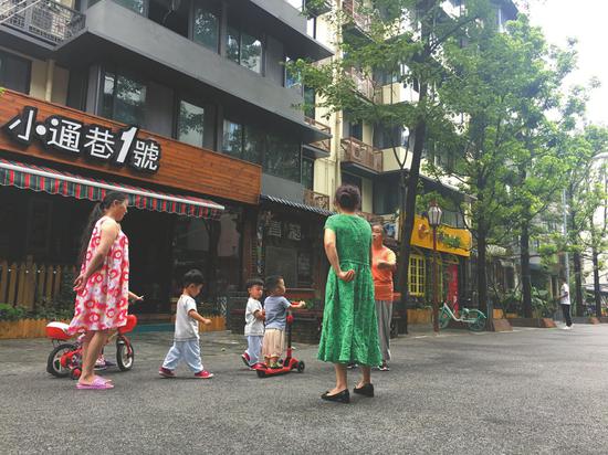 居民在泡桐树街上乘凉玩耍。
