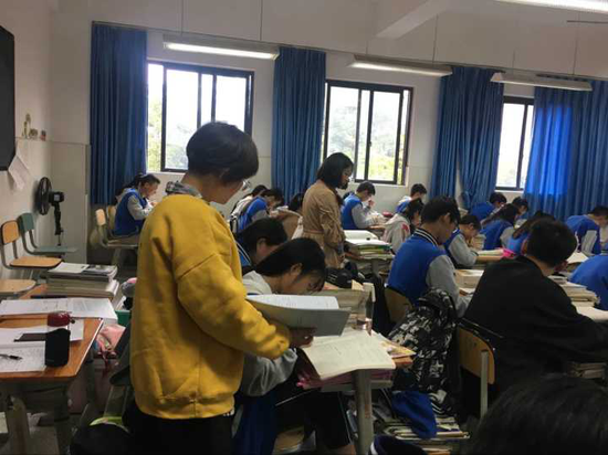 陈建华、苏明珠老师在化学课堂中巡视学生练习情况