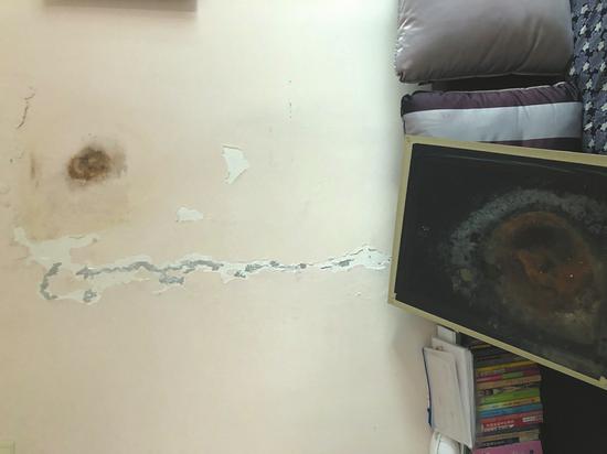 王先生家客厅墙壁部分墙皮脱落,出现霉斑水渍。